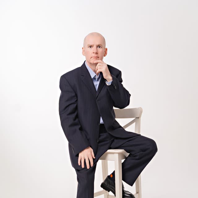 Hugh Mc Enaney — full-length studio portrait in navy suit